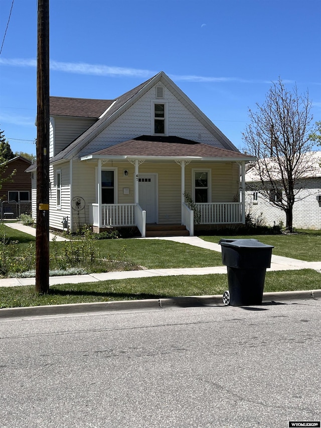 67 2nd Ave, Evanston, WY 82930 - bungalow-style house with covered porch, a front yard, and a shingled roof