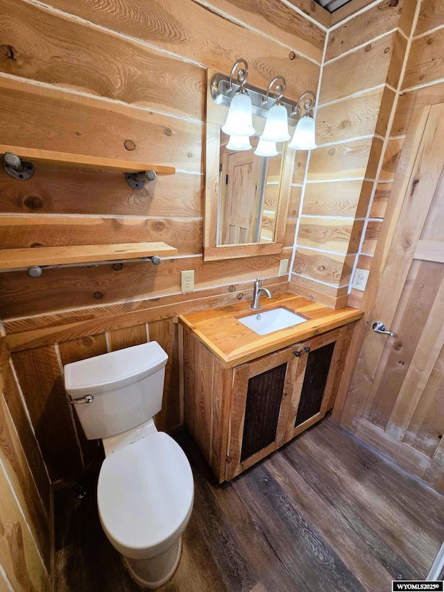 311 3rd St, Ten Sleep, WY 82442 - bathroom with wood walls, toilet, wood finished floors, and vanity