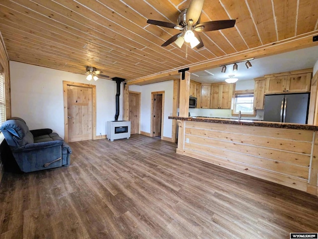 311 3rd St, Ten Sleep, WY 82442 - kitchen featuring stainless steel appliances, a wood stove, open floor plan, wooden ceiling, and light brown cabinets