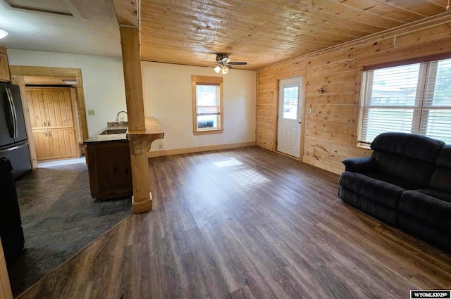 311 3rd St, Ten Sleep, WY 82442 - living room with wood ceiling, ceiling fan, baseboards, dark wood finished floors, and wood walls