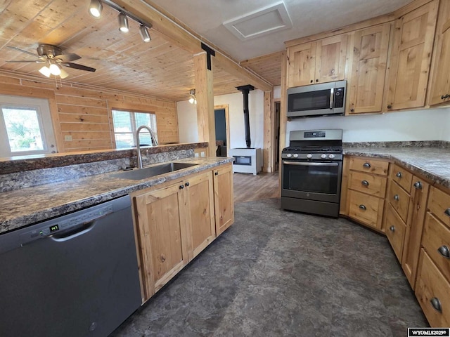 311 3rd St, Ten Sleep, WY 82442 - kitchen with appliances with stainless steel finishes, a sink, a wood stove, light brown cabinetry, and wooden ceiling