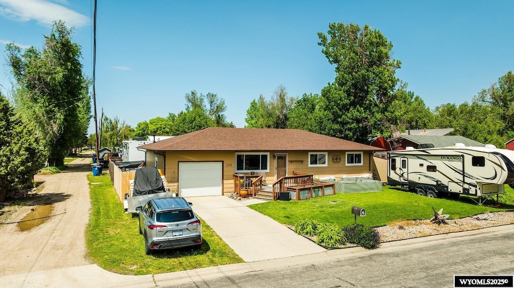 233 W 9th St, Sheridan, WY 82801 - ranch-style home featuring an attached garage, concrete driveway, a front yard, and a porch