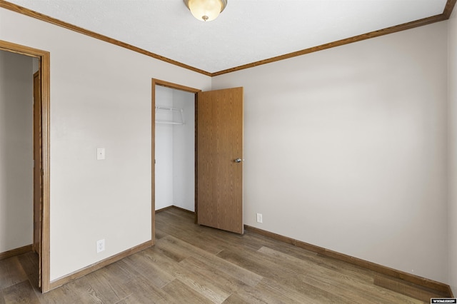 1673 Troy, Kemmerer, WY 83101 - unfurnished bedroom featuring light wood finished floors, crown molding, a closet, and baseboards