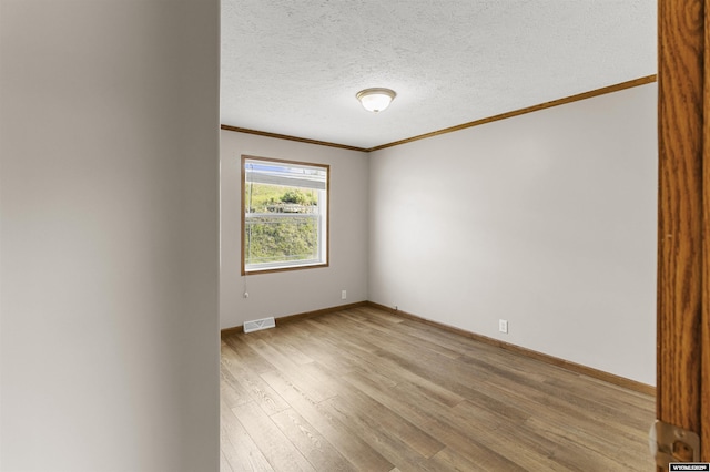 1673 Troy, Kemmerer, WY 83101 - empty room featuring crown molding, light wood-style flooring, baseboards, and a textured ceiling