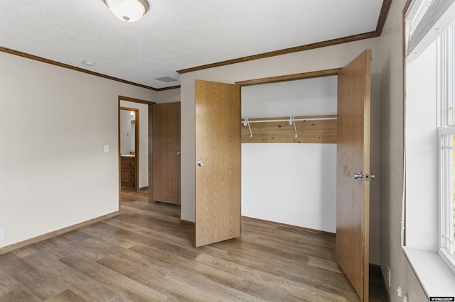 1673 Troy, Kemmerer, WY 83101 - unfurnished bedroom featuring a closet, wood finished floors, crown molding, a textured ceiling, and baseboards