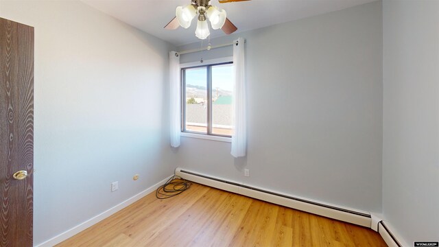 1809 Mountain View Dr, Cody, WY 82414 - empty room featuring a ceiling fan, wood finished floors, a baseboard heating unit, and baseboards