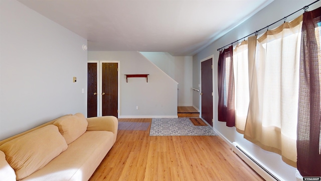 1809 Mountain View Dr, Cody, WY 82414 - living room with a baseboard heating unit, light wood-style floors, baseboards, and stairs