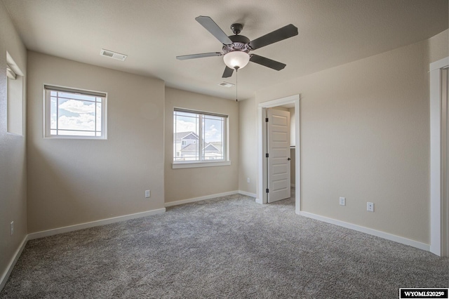 827 Dusty Ter, Mills, WY 82604 - unfurnished bedroom with multiple windows, carpet flooring, ceiling fan, and baseboards