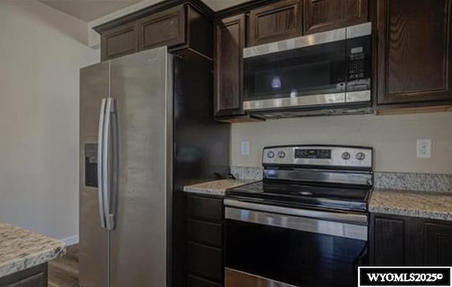 827 Dusty Ter, Mills, WY 82604 - kitchen with stainless steel appliances, dark brown cabinets, light stone counters, and wood finished floors