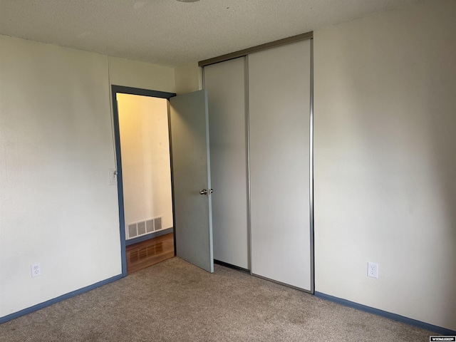 2318 Inverness Blvd, Rawlins, WY 82301 - unfurnished bedroom featuring carpet, a closet, and a textured ceiling