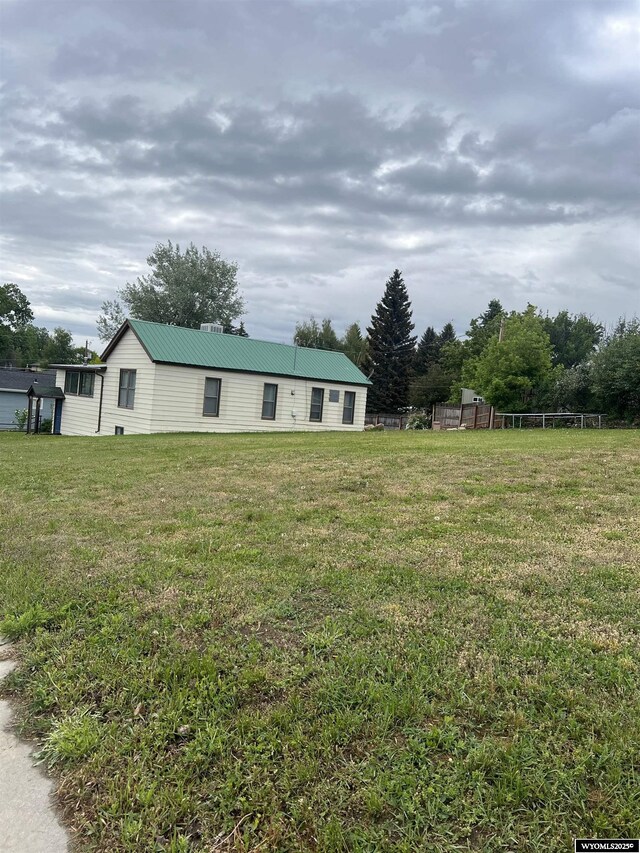 195 W Gatchell, Buffalo, WY 82834 - view of front of property with metal roof, a front yard, and a chimney
