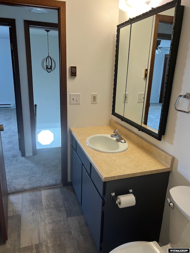 1821 Edinburgh St, Rawlins, WY 82301 - bathroom with toilet, vanity, a ceiling fan, and wood finished floors