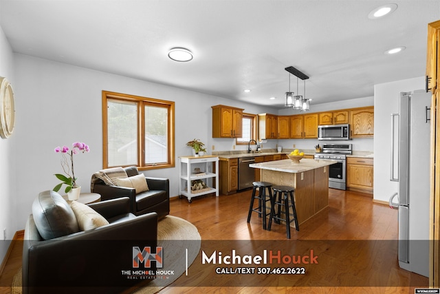 2001 Newport, Casper, WY 82609 - kitchen with stainless steel appliances, light countertops, open floor plan, a kitchen island, and dark wood finished floors