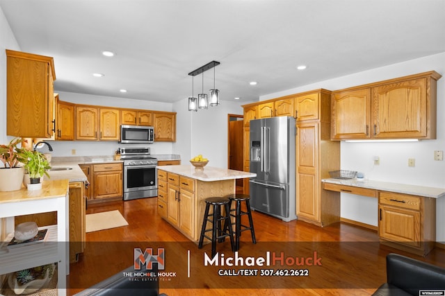 2001 Newport, Casper, WY 82609 - kitchen with stainless steel appliances, recessed lighting, dark wood-type flooring, a kitchen island, and a sink