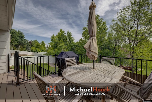 2001 Newport, Casper, WY 82609 - wooden terrace with outdoor dining area, a lawn, and view of scattered trees