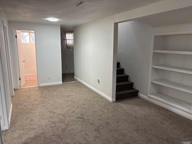 808 E Adams Ave, Riverton, WY 82501 - below grade area with a textured ceiling, carpet, baseboards, and stairway