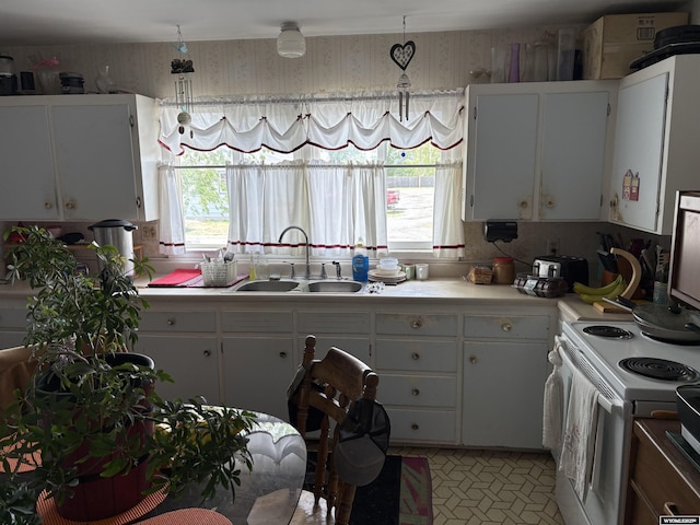 808 E Adams Ave, Riverton, WY 82501 - kitchen with a sink, wallpapered walls, light countertops, white electric range oven, and white cabinets