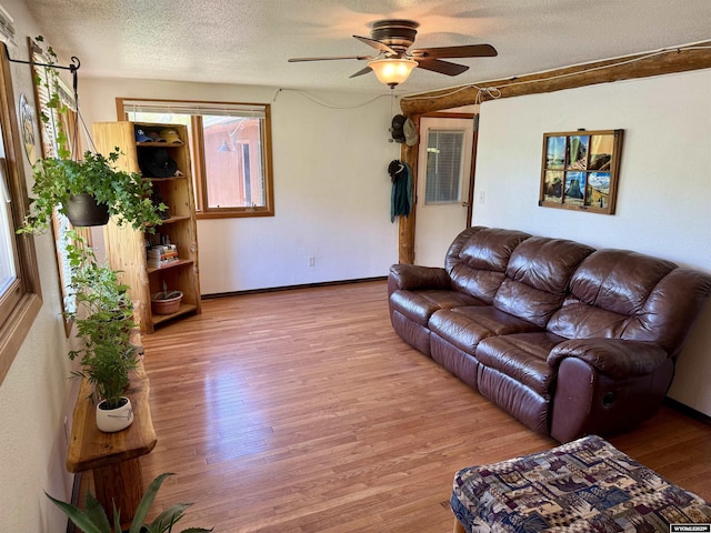 17512 US Highway 14, Carlile, WY 82721 - living area with wood finished floors, a ceiling fan, a textured ceiling, and baseboards