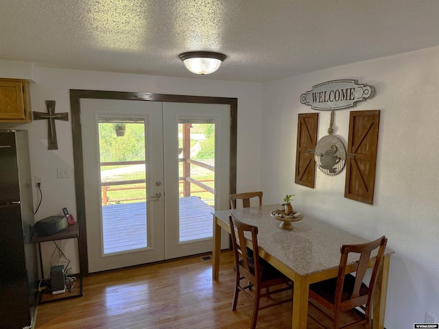 17512 US Highway 14, Carlile, WY 82721 - dining space with french doors, light wood-type flooring, and a textured ceiling