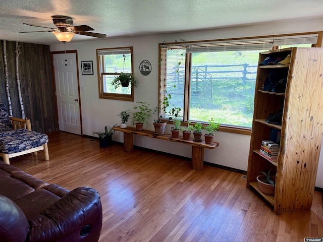 17512 US Highway 14, Carlile, WY 82721 - living room with wood finished floors, a textured ceiling, ceiling fan, and baseboards
