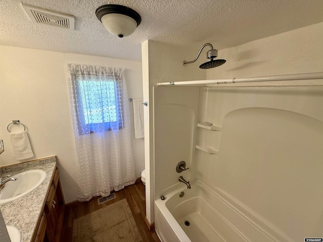 17512 US Highway 14, Carlile, WY 82721 - bathroom with tub / shower combination, a textured ceiling, wood finished floors, vanity, and toilet
