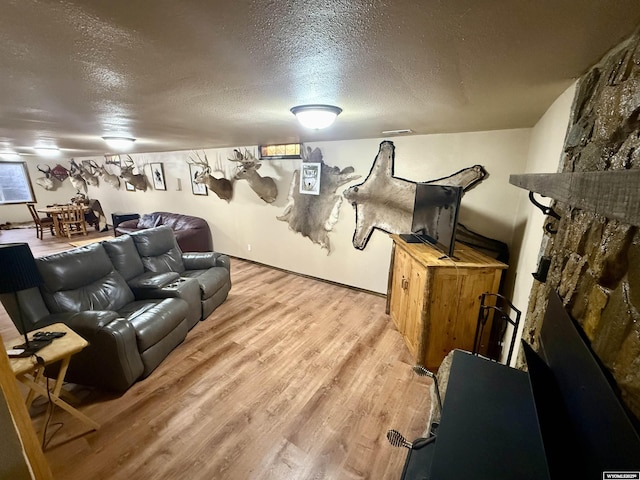 17512 US Highway 14, Carlile, WY 82721 - living area featuring a textured ceiling, light wood-style floors, and a fireplace