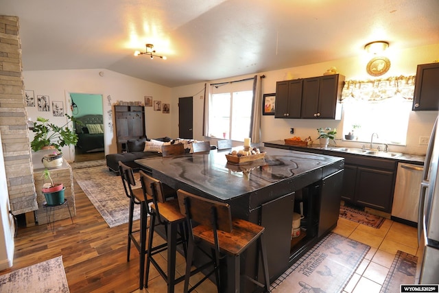 108 Tamari Dr, Buffalo, WY 82834 - kitchen with a sink, open floor plan, vaulted ceiling, dishwasher, and a kitchen island