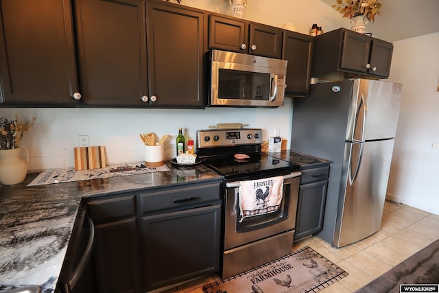 108 Tamari Dr, Buffalo, WY 82834 - kitchen with appliances with stainless steel finishes, light tile patterned flooring, and dark stone counters