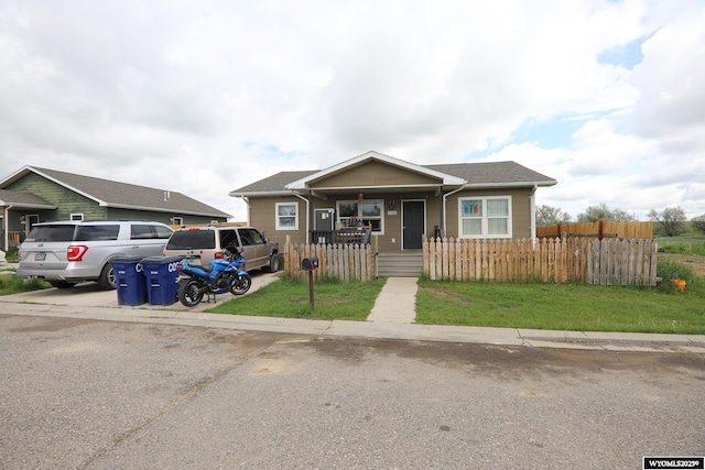 108 Tamari Dr, Buffalo, WY 82834 - bungalow-style house featuring covered porch, a fenced front yard, and roof with shingles