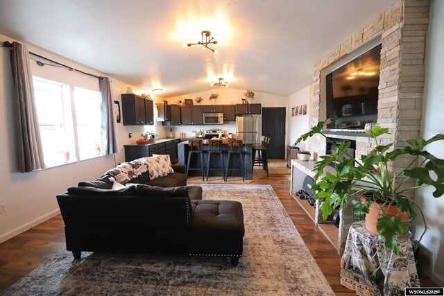 108 Tamari Dr, Buffalo, WY 82834 - living area with vaulted ceiling, dark wood-style floors, and a fireplace