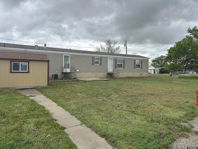608 Navy Row, Midwest, WY 82643 - back of property with entry steps, a yard, an outbuilding, and central AC