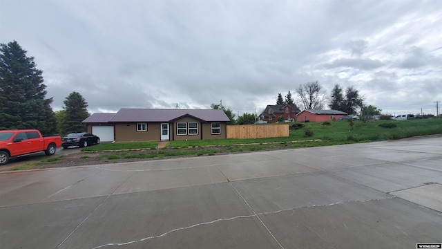 307 3rd St, Chugwater, WY 82210 - single story home with an attached garage, metal roof, and driveway