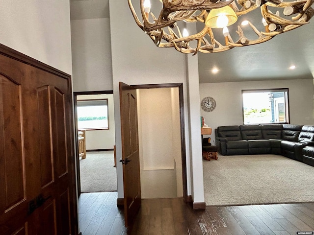 207 Eagle Dr, Greybull, WY 82426 - foyer entrance featuring dark wood-style flooring, a chandelier, and dark colored carpet