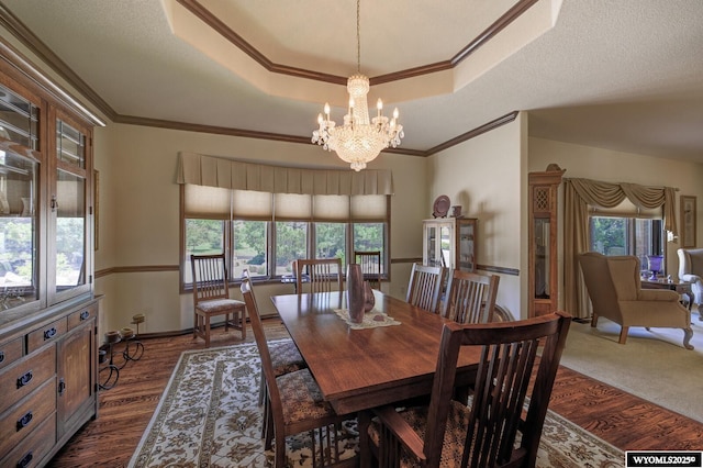 2867 Ardon Ln, Casper, WY 82609 - dining area with a raised ceiling, a chandelier, healthy amount of natural light, dark wood-type flooring, and ornamental molding