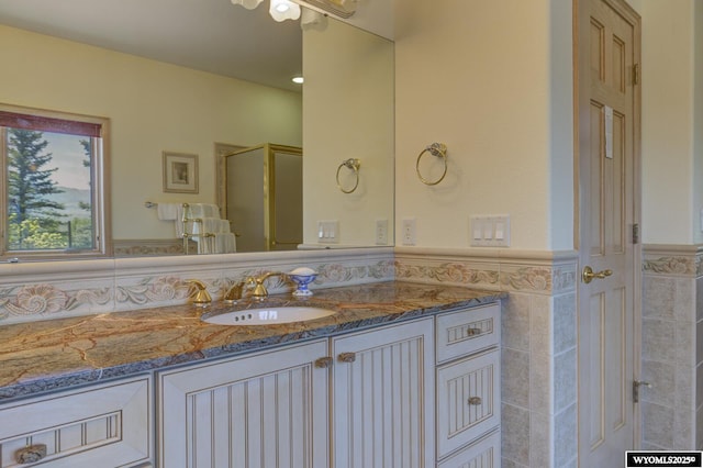 2867 Ardon Ln, Casper, WY 82609 - bathroom featuring vanity, wainscoting, and an enclosed shower