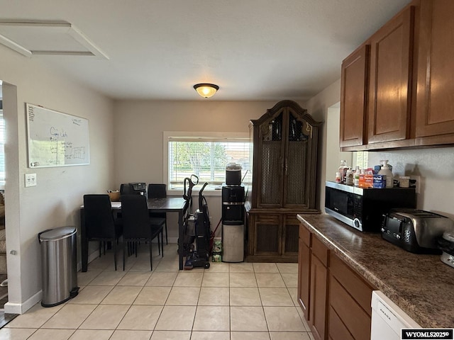 210 N 5th St W, Riverton, WY 82501 - kitchen featuring stainless steel microwave, dark countertops, light tile patterned floors, and brown cabinetry