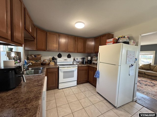 210 N 5th St W, Riverton, WY 82501 - kitchen featuring white appliances, a sink, light tile patterned flooring, and dark countertops