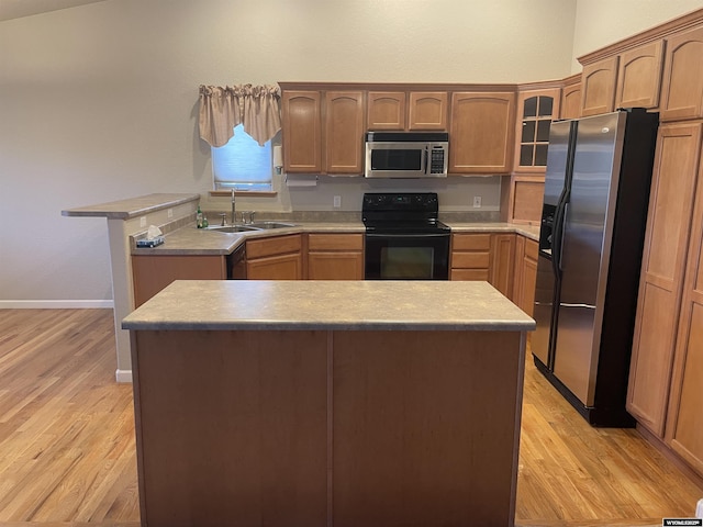 4924 Mountain Way, Casper, WY 82601 - kitchen featuring stainless steel appliances, light wood-type flooring, glass insert cabinets, light countertops, and a center island