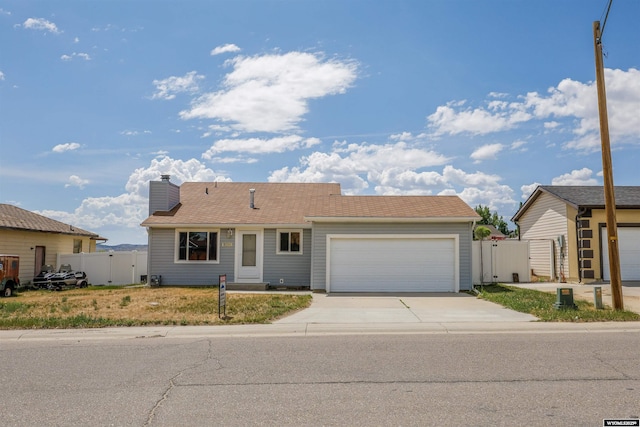 1301 Overland Dr, Rock Springs, WY 82901 - ranch-style house featuring a gate, an attached garage, concrete driveway, and a chimney