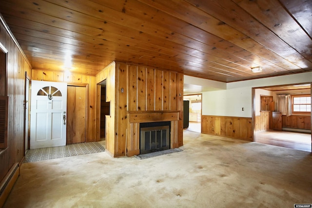1339 S Mitchell St, Casper, WY 82601 - unfurnished living room with baseboard heating, wooden walls, carpet, a wainscoted wall, and wood ceiling