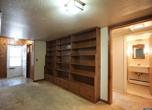 1339 S Mitchell St, Casper, WY 82601 - hallway with a baseboard heating unit, light colored carpet, and a textured ceiling