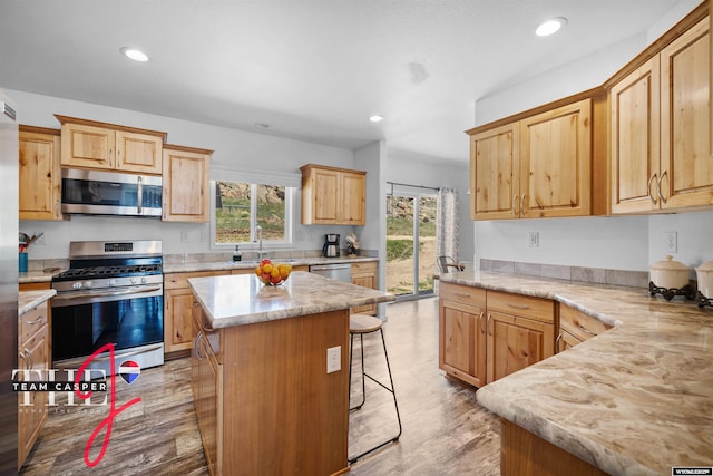 67 Monument Creek Rd, Hanna, WY 82327 - kitchen featuring appliances with stainless steel finishes, light countertops, recessed lighting, light brown cabinets, and a breakfast bar