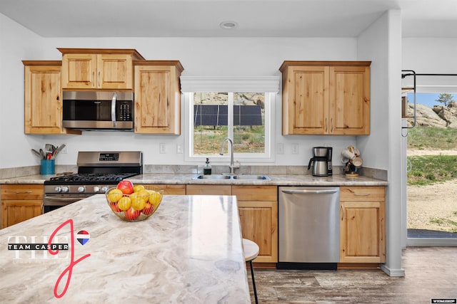 67 Monument Creek Rd, Hanna, WY 82327 - kitchen featuring stainless steel appliances, wood finished floors, plenty of natural light, and light stone countertops