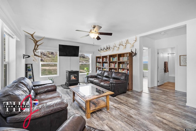 67 Monument Creek Rd, Hanna, WY 82327 - living area featuring a wood stove, a ceiling fan, and wood finished floors