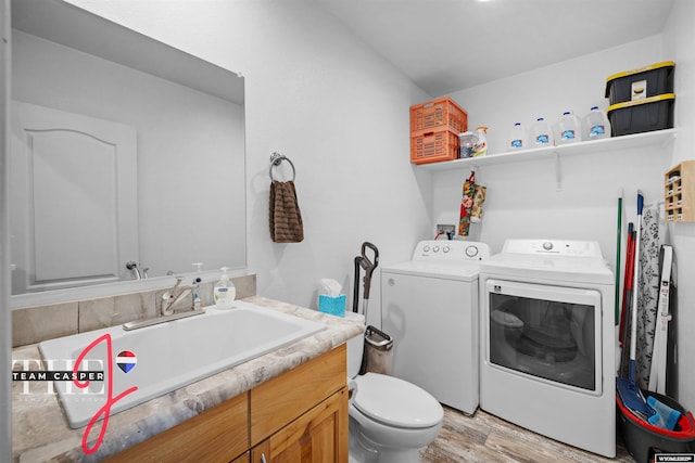 67 Monument Creek Rd, Hanna, WY 82327 - bathroom featuring washing machine and dryer, vanity, and wood finished floors