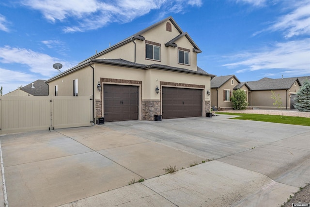 3308 Brickyard Ave, Rock Springs, WY 82901 - traditional home with driveway, stucco siding, stone siding, a gate, and an attached garage