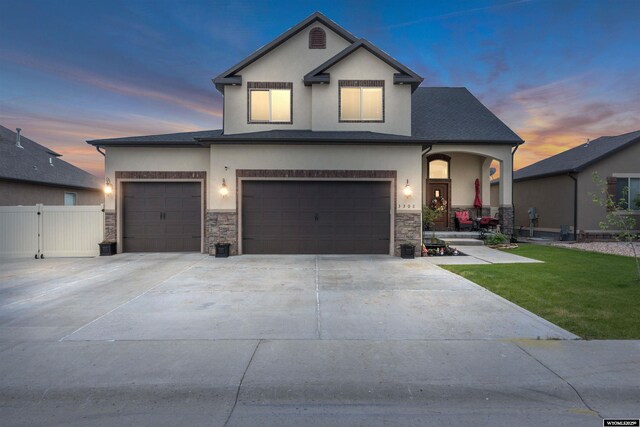 3308 Brickyard Ave, Rock Springs, WY 82901 - view of front facade featuring stucco siding, stone siding, concrete driveway, and covered porch