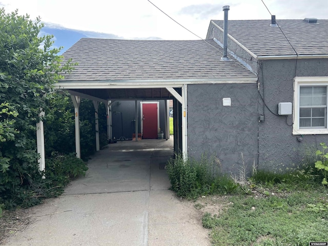 2617 E B St, Torrington, WY 82240 - view of side of home featuring a shingled roof, driveway, and stucco siding