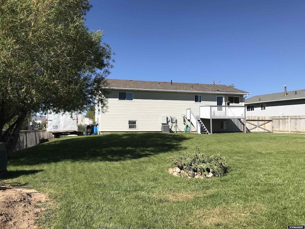 479 Twin Ridge Ave, Evanston, WY 82930 - rear view of property with stairway, a fenced backyard, and a deck