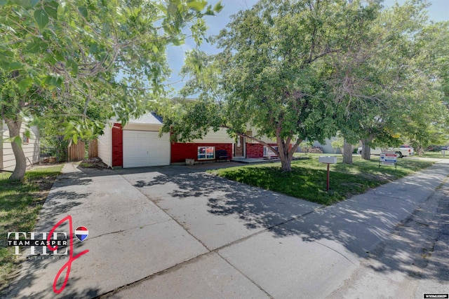 65 Calypso St, Casper, WY 82604 - obstructed view of property with a garage, concrete driveway, brick siding, and a front yard